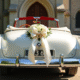 Voiture blanche de mariage décorée devant une vieille église